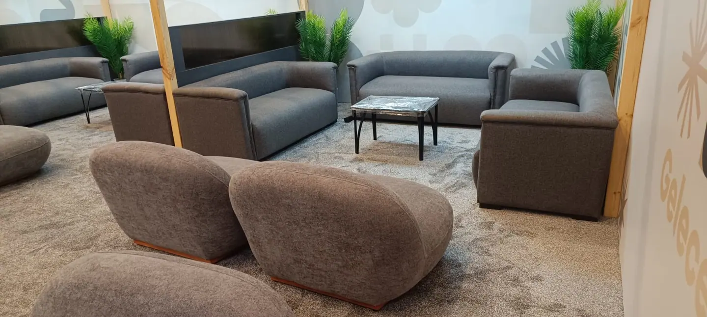 Konferans lounge alanında gri modüler koltuk ve tekli oturma yerleşimi